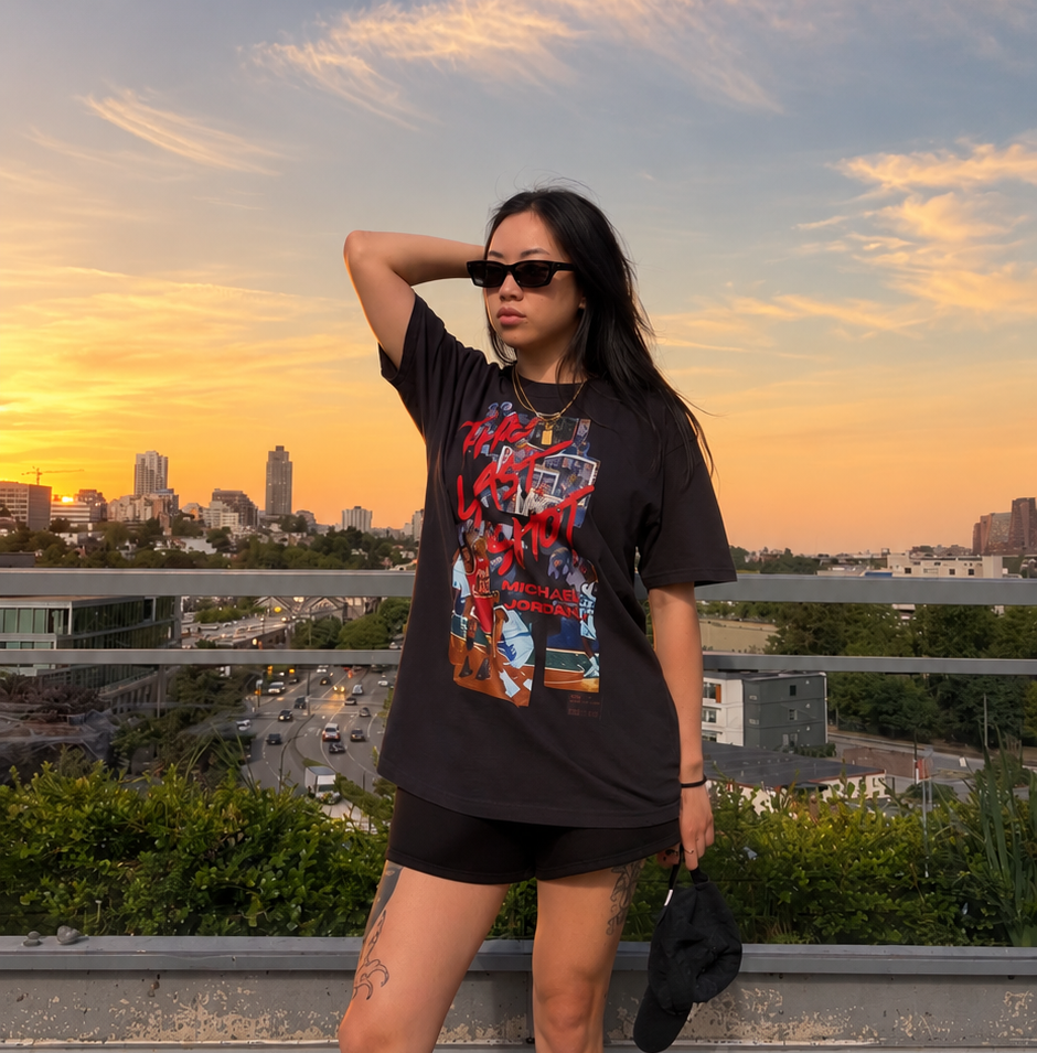 Model standing outdoors wearing The Last Shot Tee by Hai Tide in black, featuring original basketball-inspired artwork printed on a heavyweight cotton T-shirt.